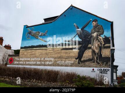 Loughborough, Leicestershire, Regno Unito. 21 febbraio 2021. Un murale sul lato di un edificio a Loughborough raffigura il leggendario Air Vice Marshal James Edgar ‘Johnnie’ Johnson, nato localmente. L'opera rende omaggio al pilota della seconda guerra mondiale RAF Spitfire, meglio conosciuto come Johnnie Johnson, che ha abbattuto più aerei nemici di qualsiasi altro pilota di combattimento alleato durante la guerra, volando circa 700 sorti operativi. Dipinto da Buber Nebz, il murale fa parte del collettivo Ladybird, che si trova dietro diverse opere d'arte che appaiono a Loughborough. Credit: Matt BLimit/Alamy Live News Foto Stock