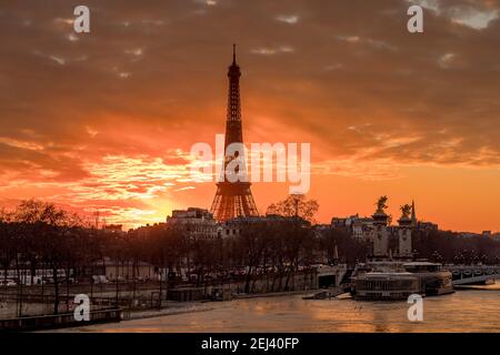 Parigi, Francia - 12 febbraio 2021: Paesaggio urbano di Parigi in inverno. Navi e brigde sul fiume Senna con la Torre Eiffel sullo sfondo e drammatico nuvoloso Foto Stock