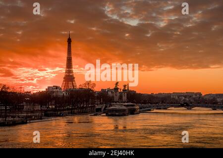 Parigi, Francia - 12 febbraio 2021: Paesaggio urbano di Parigi in inverno. Navi e brigde sul fiume Senna con la Torre Eiffel sullo sfondo e drammatico nuvoloso Foto Stock