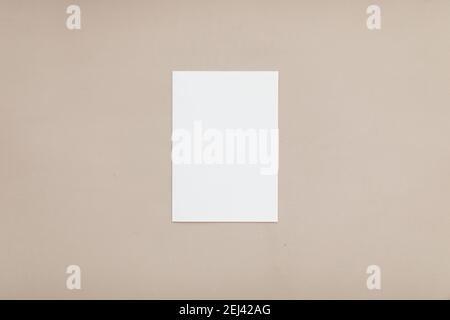 Moderna cancelleria ancora vita. Primo piano della scena del mock-up del biglietto d'auguri vuoto. Sfondo tabella beige. Disposizione piatta, vista dall'alto. Foto Stock