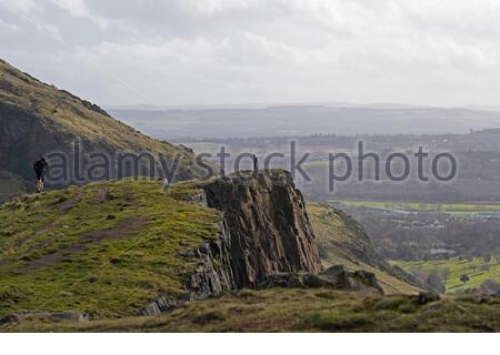 Edimburgo, Scozia, Regno Unito. 21 Feb 2021. Le persone che si godono il sole e all'aperto in Holyrood Park. Camminatori su Salisbury Crags. Credit: Craig Brown/Alamy Live News Foto Stock