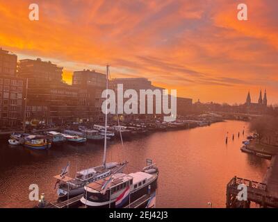 I Paesi Bassi iniziano la primavera del 2021 a febbraio ad Amsterdam il 02-21-2021 con il bagliore rosso del mattino nel cielo a. crepuscolo intorno al 07.30 Foto Stock