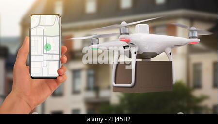 Mano con il telefono sullo sfondo del drone di consegna. Sullo schermo una mappa con un indicatore di posizione. Foto Stock