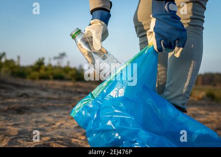 La gente deve assumersi la responsabilità! Inquinamento plastico. Attivista pulizia spiaggia da rifiuti di plastica. Pulizia ambientale. Rendi la Terra pulita! Foto Stock