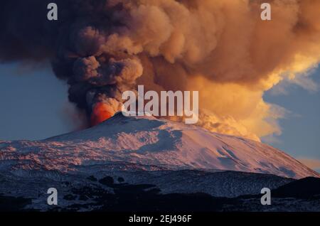 Eruzione del vulcano Etna della Sicilia simbolo della natura, dal cratere sommitale una colonna di fumo e di esplosione di lava rossa - 16 febbraio 2021 Foto Stock