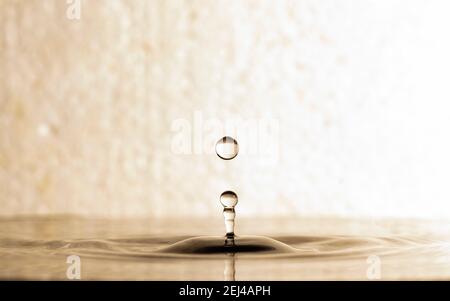 forma di goccioline d'acqua dopo la caduta sulla superficie dell'acqua increspata Foto Stock