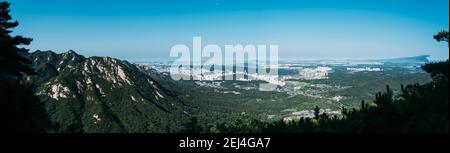 Vista panoramica dalle cime delle montagne del Parco Nazionale di Bukhansan, Seoul, Corea del Sud, con edifici e foreste sottostanti. Foto Stock