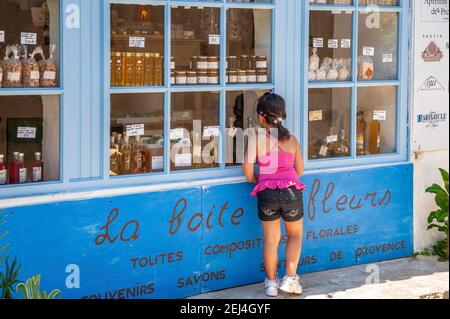 Ragazza alla finestra di un negozio di souvenir, Ramatuelle, Var, Provenza-Alpi-Costa Azzurra, Francia Foto Stock