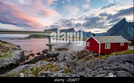 Tradizionali case di palafitte rosse, capanna di pesca tipica con ponte, Reine, Lofoten, Nordland, Norvegia Foto Stock
