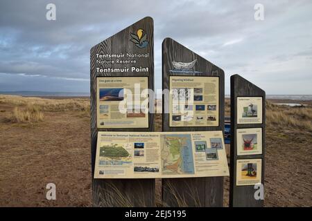 Grande bacheca di informazioni in legno presso la riserva naturale nazionale di Tentsmuir, Fife, Scozia. Mappe di area e informazioni sulla fauna selvatica. Sfondo costiero Foto Stock