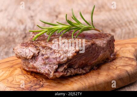 Bistecca alla griglia su legno con rosmarino Foto Stock