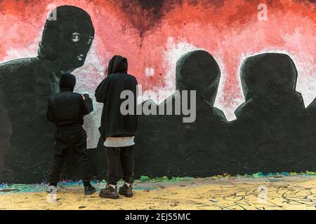 Barcellona, Spagna. 21 Feb 2021. Artisti di strada dipingono graffiti a sostegno dell'artista rap imprigionato Pablo Hasel. Condannati a prigione per glorificare il terrorismo e insultare l'ex re spagnolo in lyrics, dopo cinque notti di disordini. Credit: Matthias Oesterle/Alamy Live News Foto Stock