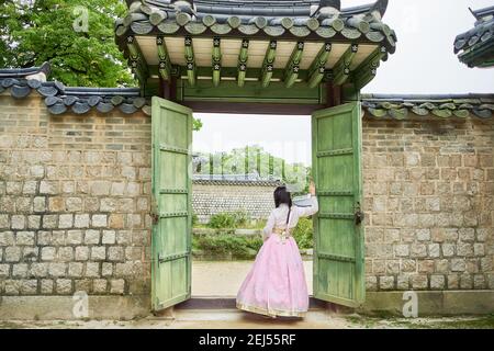 Donna asiatica che indossa un tradizionale abito hanbok rosa a Changdeokgung Palace, Seoul, Corea del Sud Foto Stock