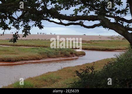 Il fiume marrone e tortuoso Otter scorre attraverso la pianura alluvionale e la riserva naturale di Budleigh Salterton, Devon, prima di entrare nel mare. Foto Stock