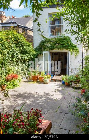 Un giardino ombreggiato e tranquillo patio in una zona residenziale di North London, UK Foto Stock