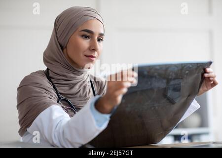 Ritratto di una donna musulmana dottoressa medica guardando i raggi X. Foto Stock