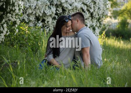 giovane coppia baciando teneramente in una data romantica in un parco primaverile Foto Stock