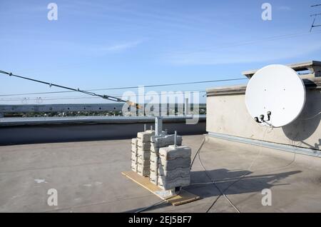 Contrappeso o bilanciamento del peso blocchi di calcestruzzo o mattoni come parte di una piattaforma di funi sospese per lavori di facciata su edifici ad alto livello multipiano. Uomo Foto Stock