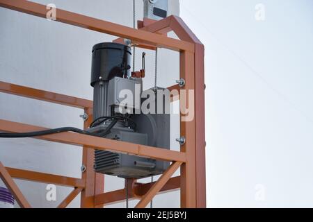 Fornitura di paranco e blocco di sicurezza come parte della piattaforma a fune sospesa per lavori di facciata su edifici alti a più piani. Paranco per sollevamento, sollevamento o l Foto Stock