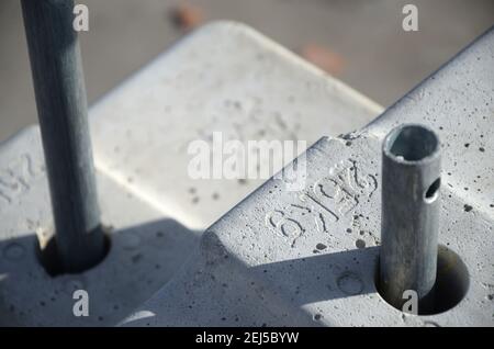 Contrappeso o bilanciamento del peso blocchi di calcestruzzo o mattoni come parte di una piattaforma di funi sospese per lavori di facciata su edifici ad alto livello multipiano. Uomo Foto Stock