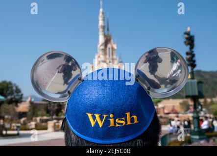 Hong Kong, Cina. 19 Feb 2021. Un dipendente indossa un cappello a tema Micky mouse all'ingresso del parco Disneyland di Hong Kong durante la riapertura a Hong Kong, in Cina, il 19 febbraio 2021. L'Hong Kong Disneyland Resort riapre le sue porte alle autorità come il governo della città ha allentato le restrizioni di blocco, come il tasso di infezione del Coronavirus Covid-19 ha ridotto significativamente negli ultimi giorni. Credit: Miguel candela/SOPA Images/ZUMA Wire/Alamy Live News Foto Stock