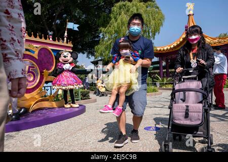 Hong Kong, Cina. 19 Feb 2021. Una famiglia ha la loro foto scattata con i personaggi di Micky mouse e Minnie Disney come hanno bisogno di mantenere le regole di divaricamento sociale a Disneyland Resort a Hong Kong, Cina il 19 febbraio 2021. L'Hong Kong Disneyland Resort riapre le sue porte alle autorità come il governo della città ha allentato le restrizioni di blocco, come il tasso di infezione del Coronavirus Covid-19 ha ridotto significativamente negli ultimi giorni. Credit: Miguel candela/SOPA Images/ZUMA Wire/Alamy Live News Foto Stock