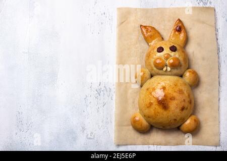 Cottura pasquale fatta in casa. Pasqua Bunny Bun su sfondo grigio chiaro textured, piatto, spazio Foto Stock