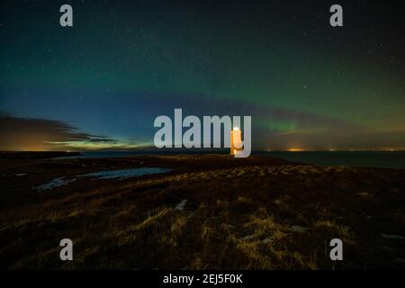 Faro sulla penisola di Reykjanes nortern sotto le luci. L'Islanda. Il timelapse Foto Stock