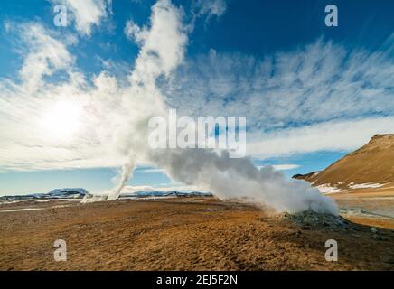Namafjall Hverir zona geotermica in Islanda. Splendido paesaggio di valle dello zolfo con fumarole fumanti e cielo blu nuvoloso, sfondo di viaggio Foto Stock