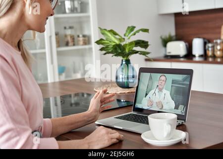 Paziente di mezza età femmina ottenere online telemedicina consultazione a casa. Foto Stock