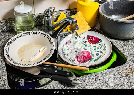 Set di piatti sporchi, posate e padelle nel lavandino pronti per essere lavati. Foto Stock