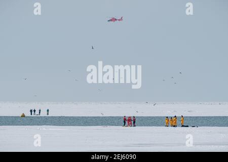 Cleveland, Ohio, Stati Uniti. 21 Feb 2021. Le persone vengono salvate dal ghiaccio del lago Erie dai membri della USCG Ice Rescue Team da Station Cleveland, così come da altre agenzie di soccorso locali, a fine domenica pomeriggio, 21 febbraio 2021 all'Edgewater Park di Cleveland, Ohio. Alle 12:43 EST, il Servizio meteorologico Nazionale a Cleveland emettere un avvertimento per non andare sul ghiaccio a causa dello sviluppo di crepe significative da venti meridionali. Secondo un Tweet dell'USCG Great Lake, la squadra di salvataggio del ghiaccio '''¦ USCG ha salvato 6 individui attraverso lo skiff del ghiaccio e gli altri 4 sono stati scortati via il ghiaccio da Cleveland F. Foto Stock