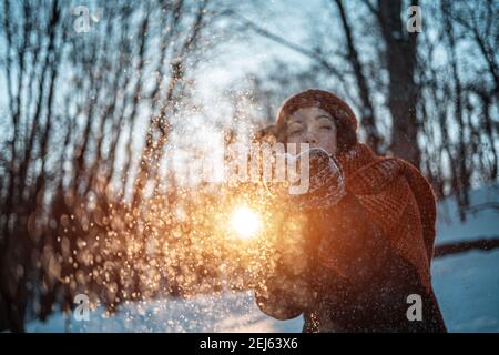 bella donna felice che gioca con la neve e divertirsi all'aperto nel parco invernale Foto Stock