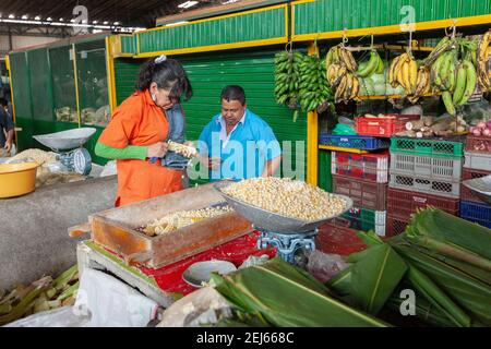 Colombia Medellin uomo e Donna rimozione di noccioli da pannocchie di mais All'interno di Plaza Minorista José María Villa Market Foto Stock