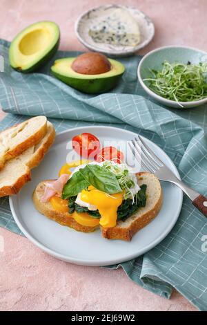 Gustosa colazione con uova fiorentine e verdure fresche a colori sfondo Foto Stock