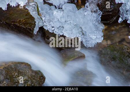 Acqua che scorre sotto ghiaccio fondente, concetto di riscaldamento globale Foto Stock