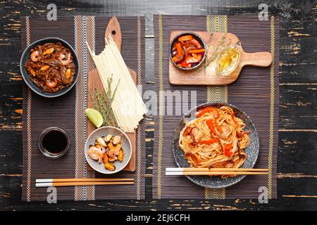 Piatti con tagliatelle cinesi su sfondo di legno Foto Stock