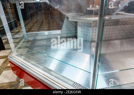 Scaffali vuoti in un supermercato in mezzo al coronavirus pandemia. Chiusura del centro commerciale. Frigoriferi commerciali vuoti presso il negozio di alimentari. Cibo surgelato esaurito Foto Stock