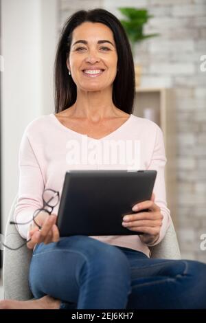 Eleganti donna di mezza età con tablet pc a casa Foto Stock