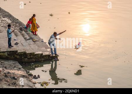 Kolkata, India. 21 Feb 2021. Un devoto immerge l'idolo Saraswati al santo Ganga. L'inquinamento idrico è uno dei maggiori problemi ambientali in India per varie ragioni. A Kolkata, ogni volta dopo ogni genere di pujas o festival religiosi, il fiume più santo, il Gange diventa terribilmente inquinato a causa del numero crescente di immersione idolo & spazzatura di leftover. Giorno dopo giorno il Gange sta perdendo la sua capacità di flusso e Kolkata, insieme ai suoi distretti circostanti, si trova a fronteggiare i peggiori problemi di alluvione ogni anno. Credit: SOPA Images Limited/Alamy Live News Foto Stock