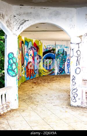 Le rovine di un villaggio turistico, hotel o casa rumed forniscono una tela per i graffiti artistici lavori di mano nella giungla vicino Jaco, Costa Rica. Foto Stock