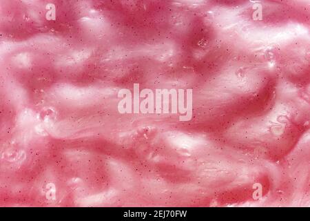 Sfondo full frame di melma rosa gooey, un giocattolo per bambini prodotto con gomma guar con una texture amorfa malleabile squishy slimy in primo piano Foto Stock