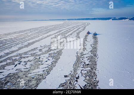 Due rompighiaccio sul fiume Vistola schiacciano il ghiaccio in inverno, vista aerea della Polonia Foto Stock