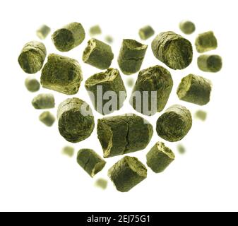 Luppolo granulato verde a forma di cuore uno sfondo bianco Foto Stock
