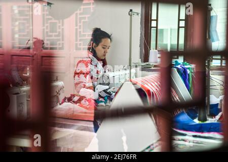 (210222) -- QIANXI, 22 febbraio 2021 (Xinhua) -- Yang Wenli del gruppo etnico Miao fa i costumi Miao ad un laboratorio di riduzione della povertà nel villaggio di Huawu, nella contea di Qianxi della città di Bijie, nella provincia sudoccidentale di Guizhou, 20 febbraio 2021. Situato nella profonda area montagnosa di Xinren Miao Township di Guizhou, Huawu Village è famoso per i suoi paesaggi incredibili. Negli ultimi anni, con gli sforzi del governo locale, il villaggio sviluppa la piantagione, la coltivazione e il turismo mentre delocalizza le persone colpite dalla povertà. Oggi Huawu ha assunto un nuovo look nel nuovo anno, con diverse industrie saluto boo Foto Stock