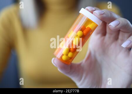 Donna che tiene il vaso di capsule nel suo closeup mani Foto Stock