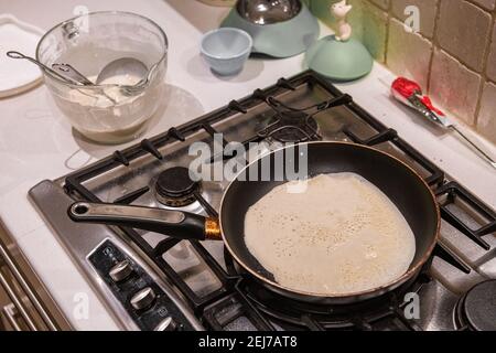 Un pancake cucina su un piano cottura a gas il giorno pancake, Shrove Martedì Foto Stock