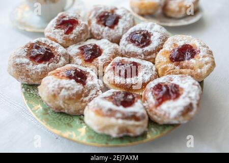 Un piatto di ciambelle ripieno di marmellata e ricoperto di zucchero. Foto Stock