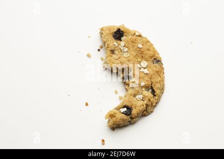 Vista dall'alto di un biscotto mangiato a metà con un piccolo cioccolato chip isolati su sfondo bianco Foto Stock