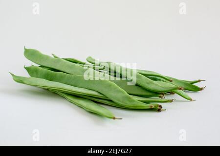 un gruppo di chicchi di runner freschi verdi piatti su bianco sfondo isolato con spazio di copia Foto Stock